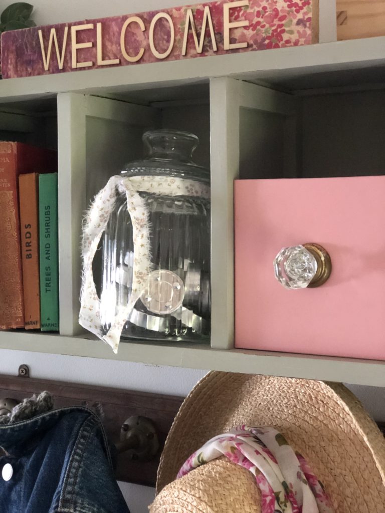 glass jar with tealights on in repurposed cd storage unit with pink box