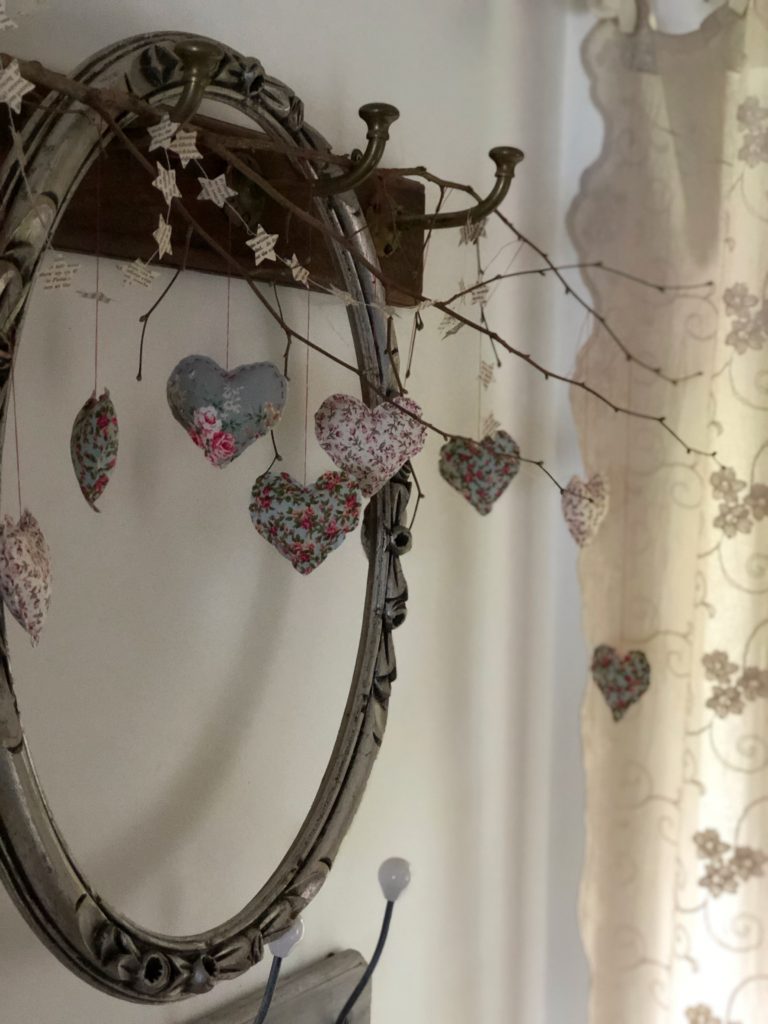 decorative fabric heart garland on hallway hooks with empty frame