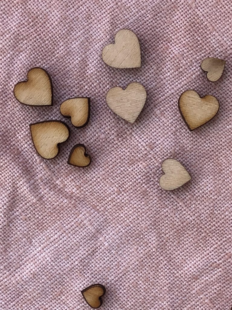 mini wooden hearts on top of avocado dyed cloth