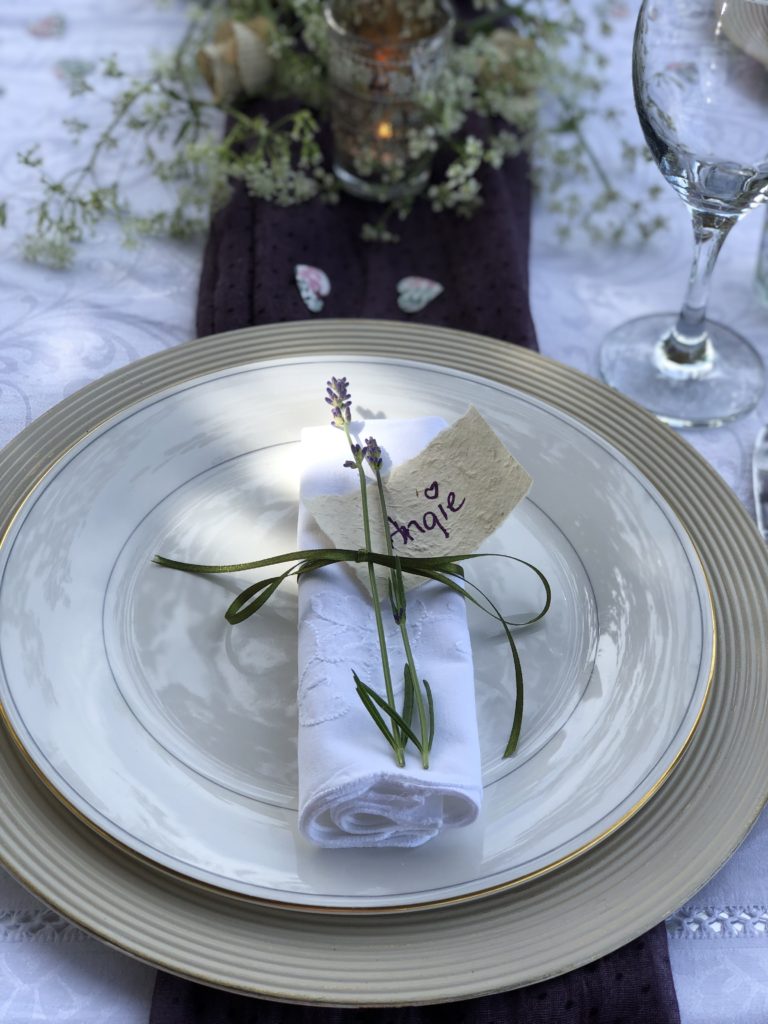 white plate on gold charger with napkin and lavender detail create simple table decoration