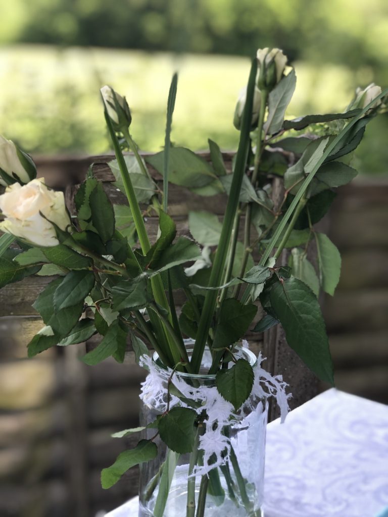 white roses in glass jar create simple table decoration