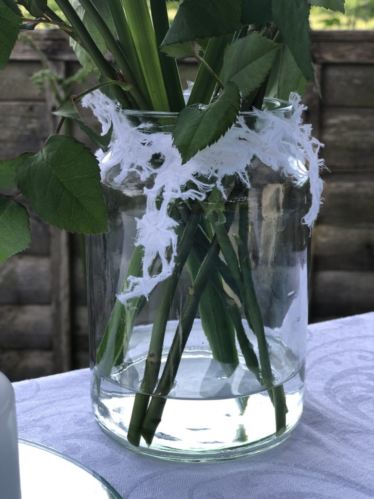 white roses in glass jar create simple table decoration