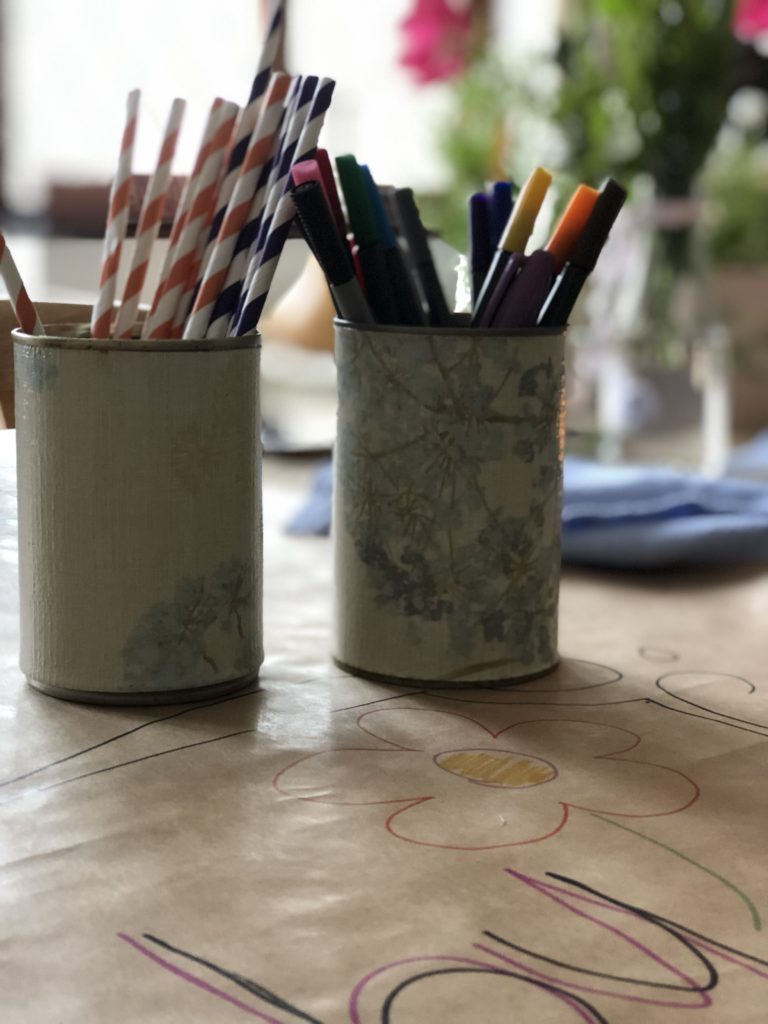 recycled and decoupaged tin cans hold cutlery, napkins and straws at summer wedding table