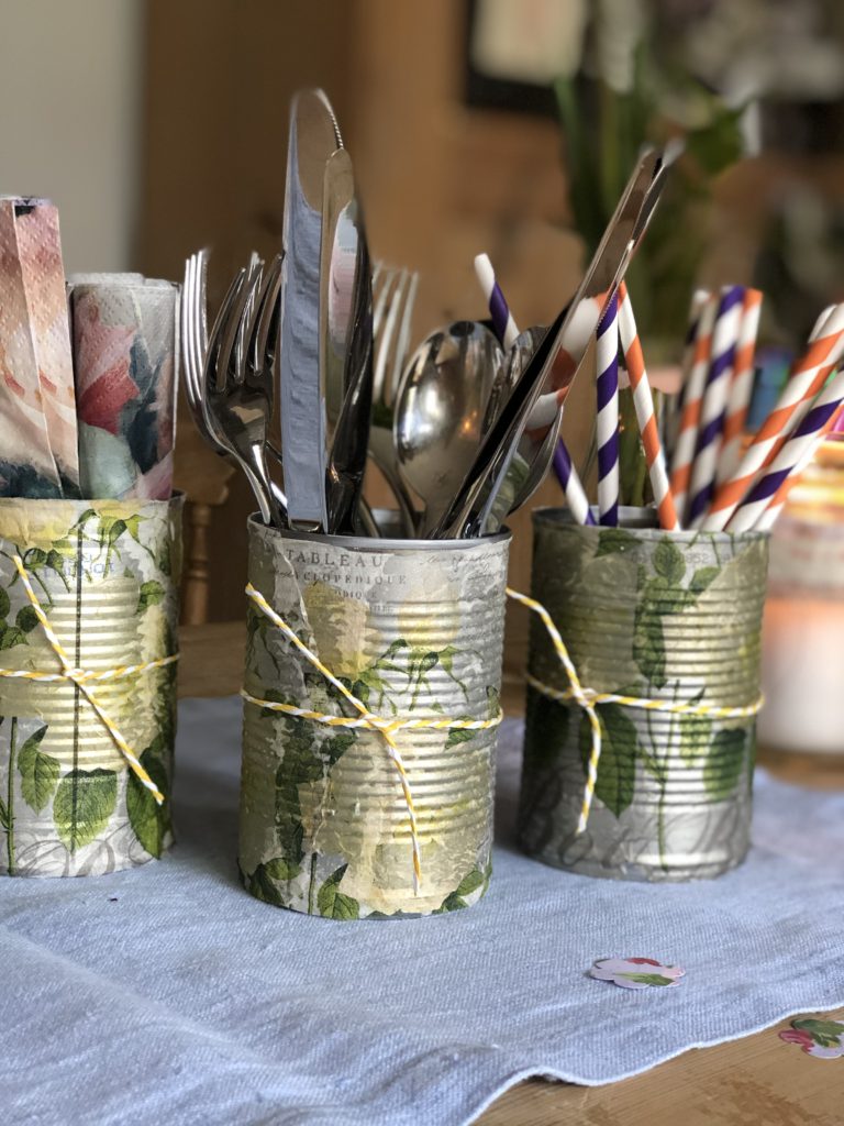 recycled and decoupaged tin cans hold cutlery, napkins and straws at summer wedding table