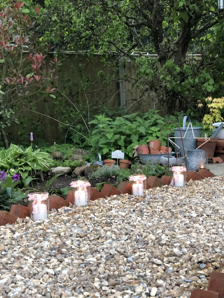 candles in jam jars light a shingled pathway