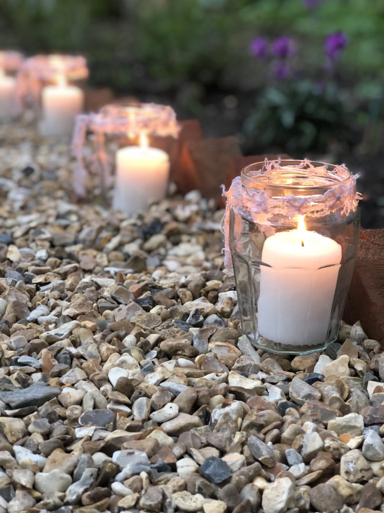 candles in jam jars light a shingled pathway