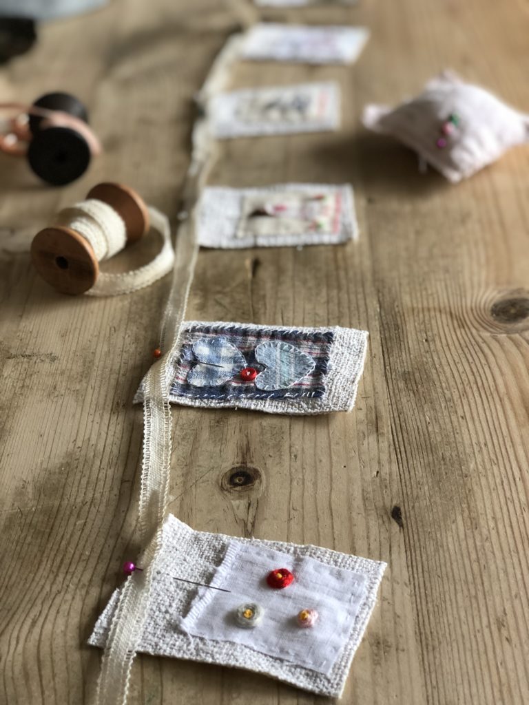 pinning fabric embroidered bunting flags to vintage ribbon