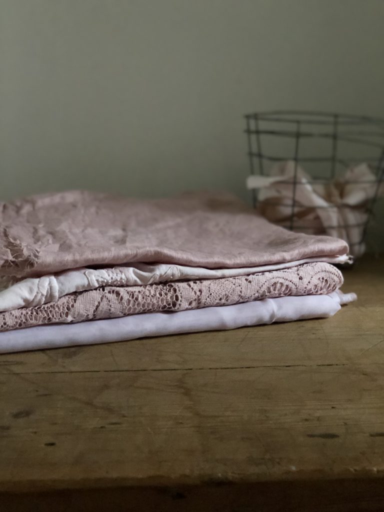 selection of avocado dyed vintage fabrics on table with wire basket