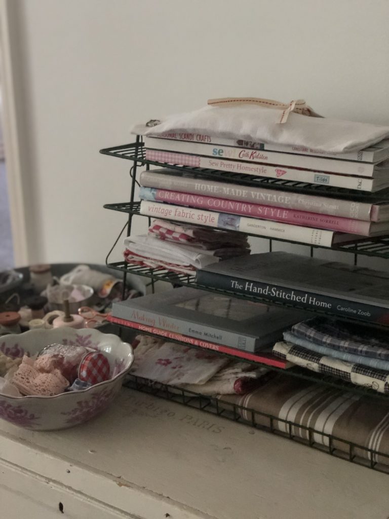 wire shelving rack with sewing books and fabrics and threads