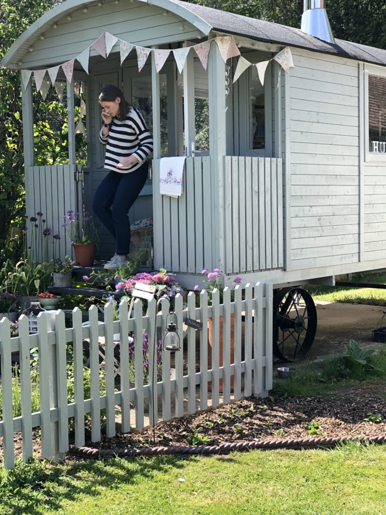 Stylist leaving shepherds hut during Period Living Magazine photo shoot