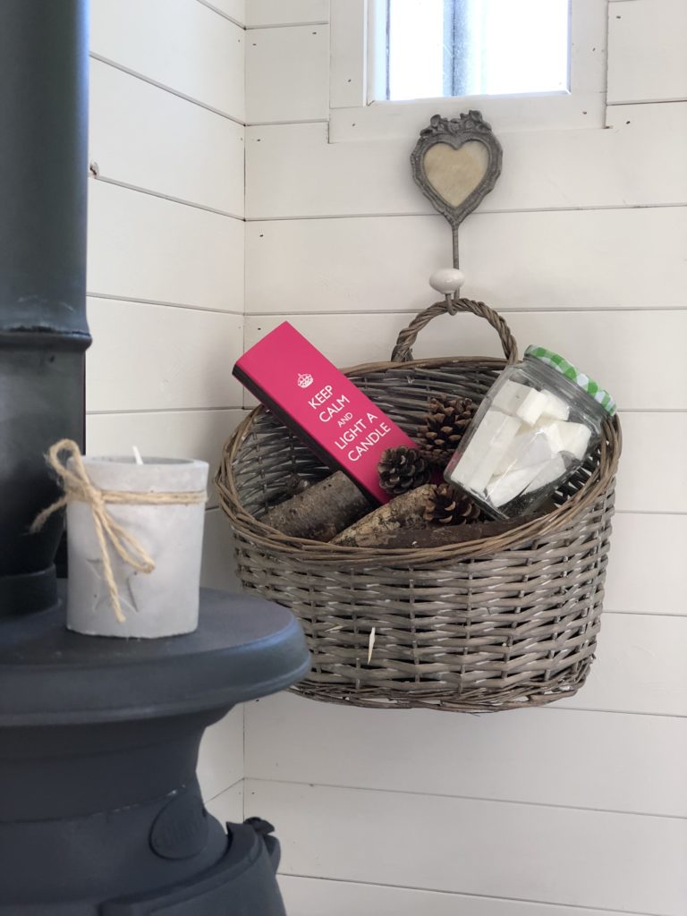 glass jar with firelighters matches and kindling in basket