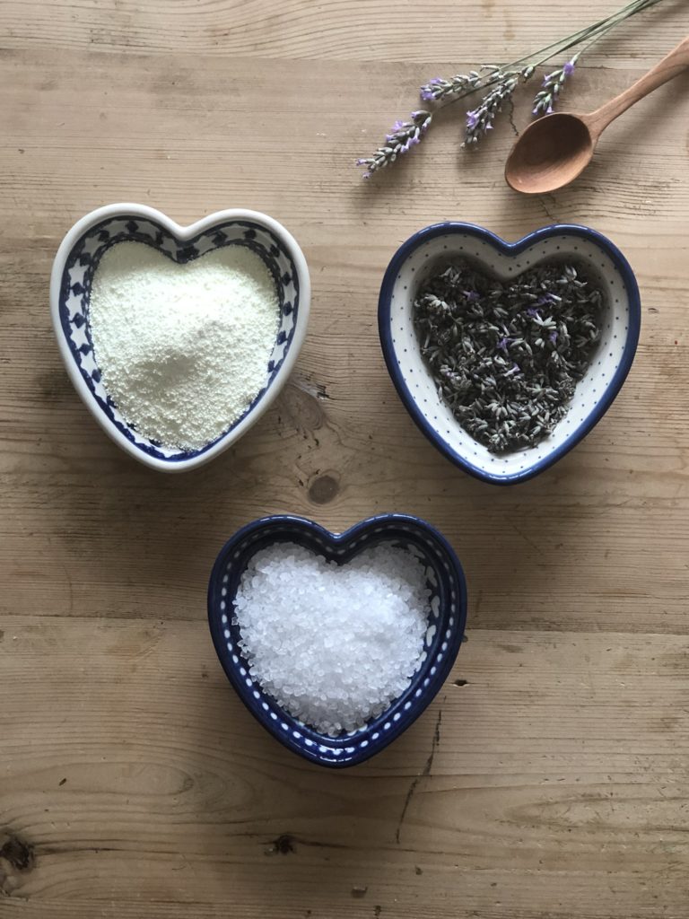 flat lay of 3 blue pottery heart dishes with lavender, salt and milk powder 