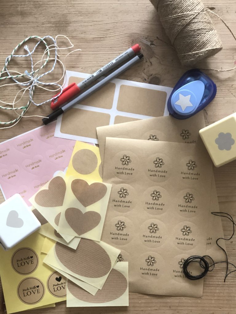 variety of sticky labels, wooden buttons, string, hole punches and pens