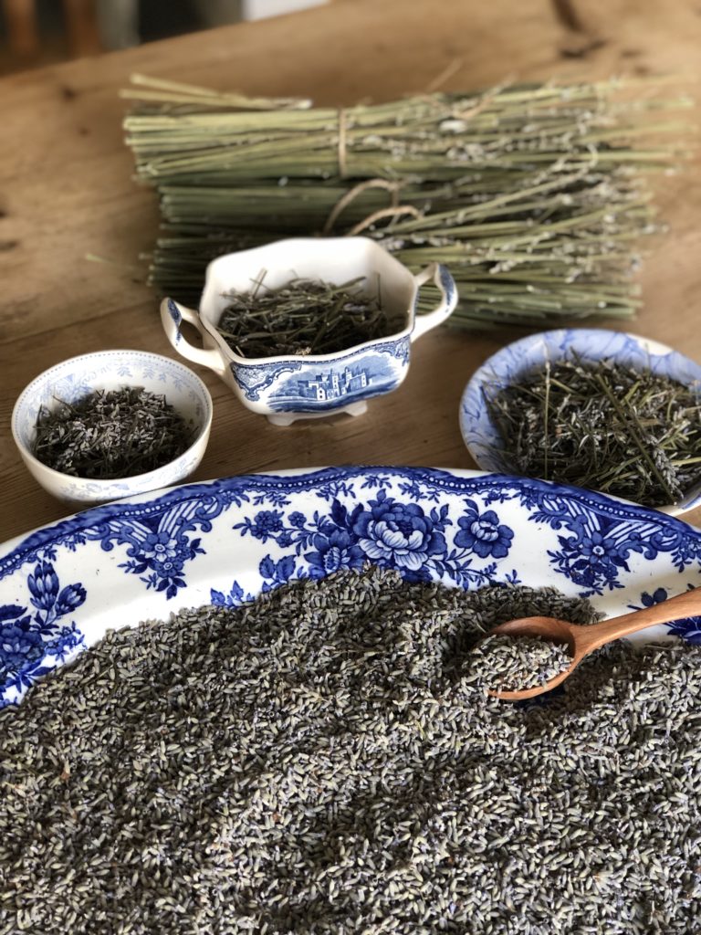 dried lavender buds in blue ceramics with wooden spoon