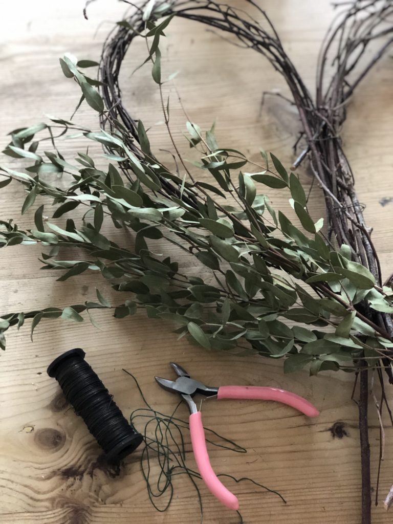 adding foliage to willow heart wreath