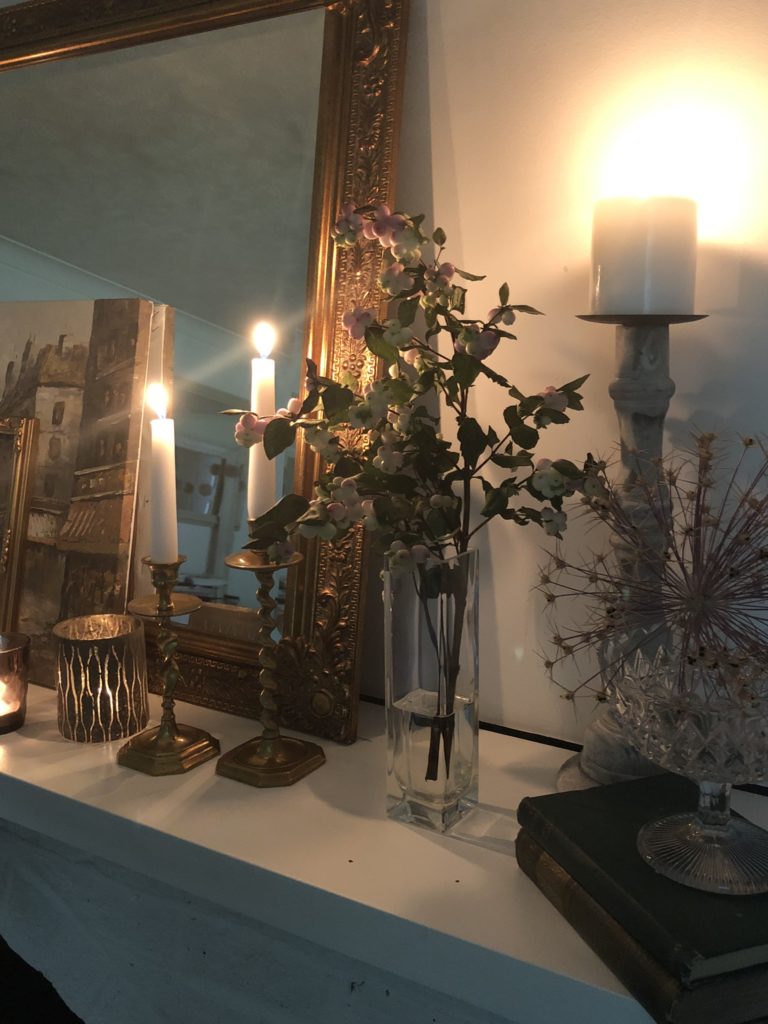 snowberries and candlelight on mantle piece