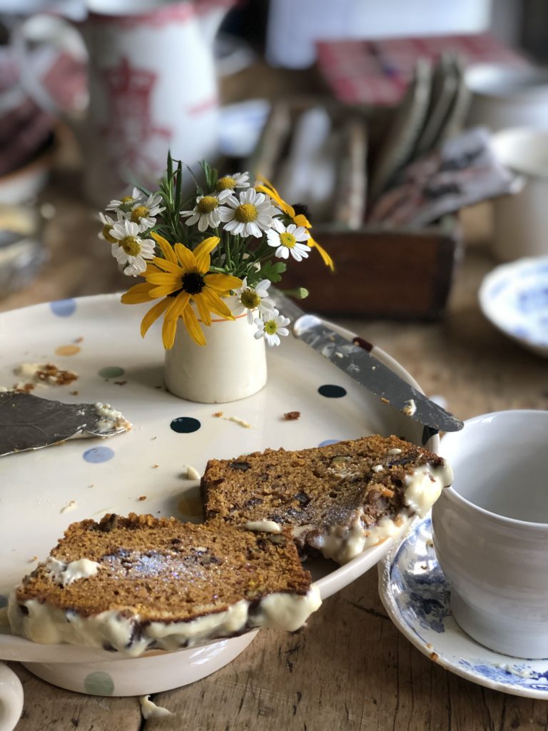 buttered tea bread on pretty plate with small jug of flowers