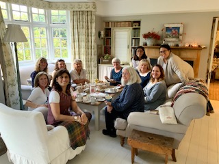 group of ladies gather around coffee table smiling