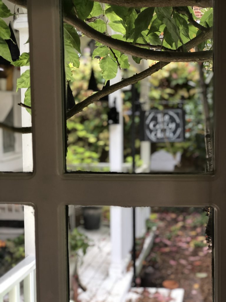 looking through a window to the cozy club sign