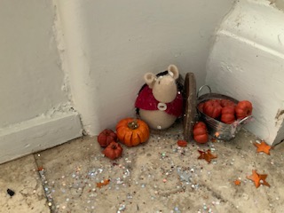 toy mouse and mini pumpkins and glitter at foot of stairs