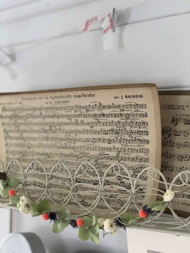 music sheets on wire shelves with homemade autumn garland