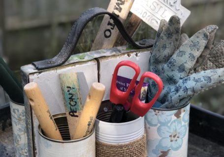 tin can organiser with gardening equipment