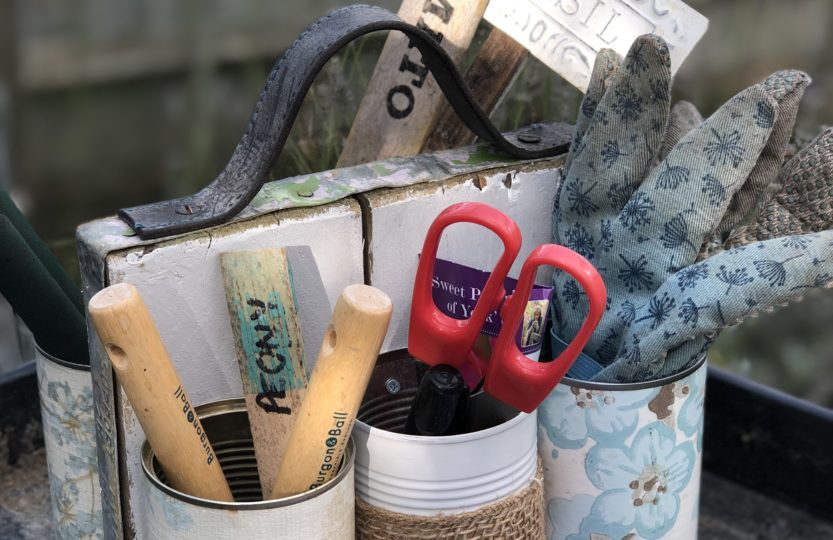 tin can organiser with gardening equipment