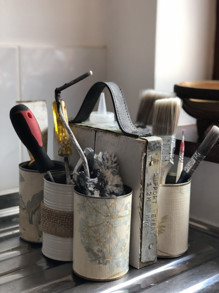 homemade tin can organiser with paint brushes