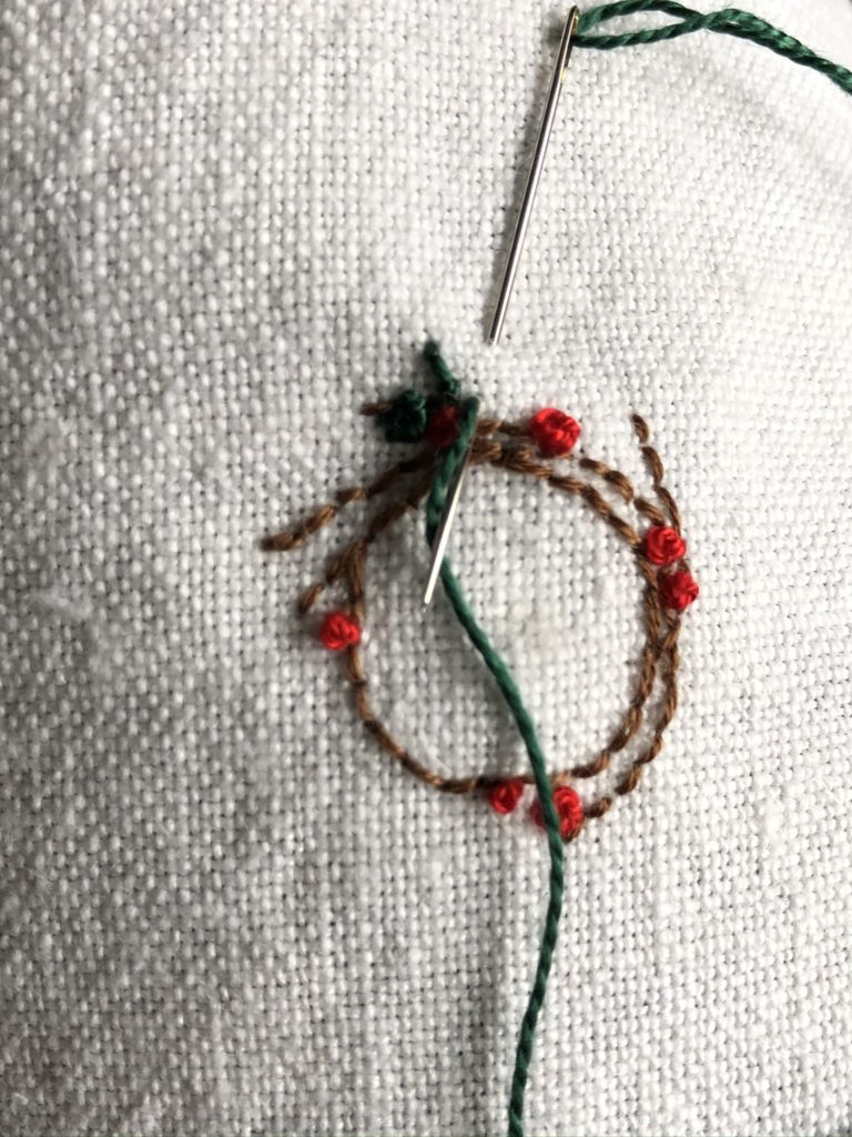 Stitching a Christmas wreath onto linen