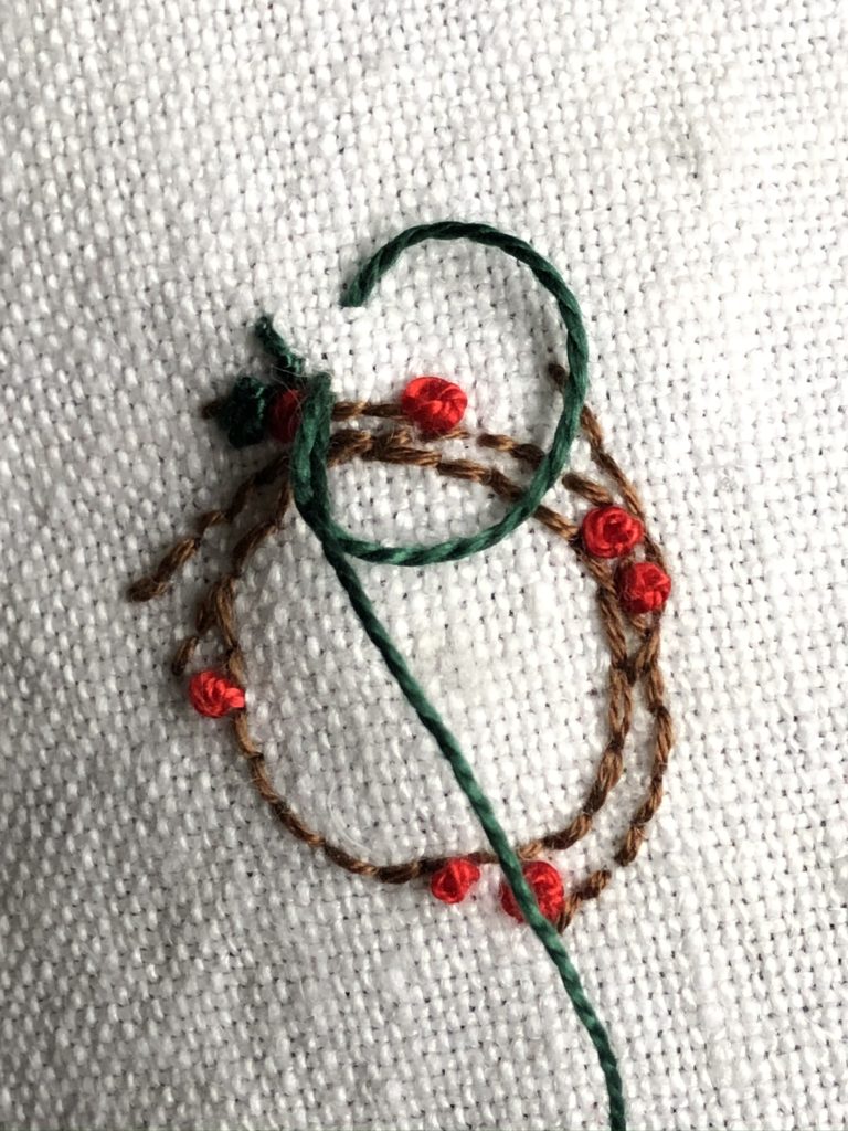 Stitching a Christmas wreath onto linen