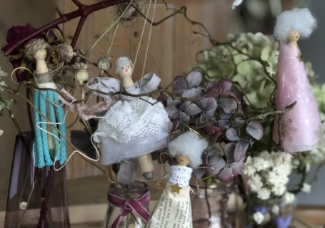 four peg doll Christmas fairies hanging amongst dried hydrangeas