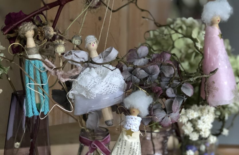 four peg doll Christmas fairies hanging amongst dried hydrangeas