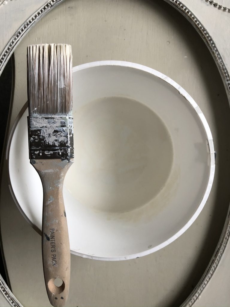 flatlay of paint brush and plastic paint kettle