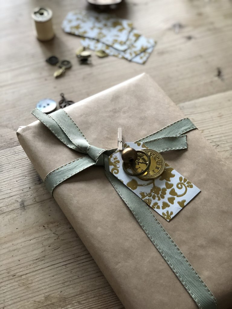 brown paper gift wrapping with gold and green ribbons