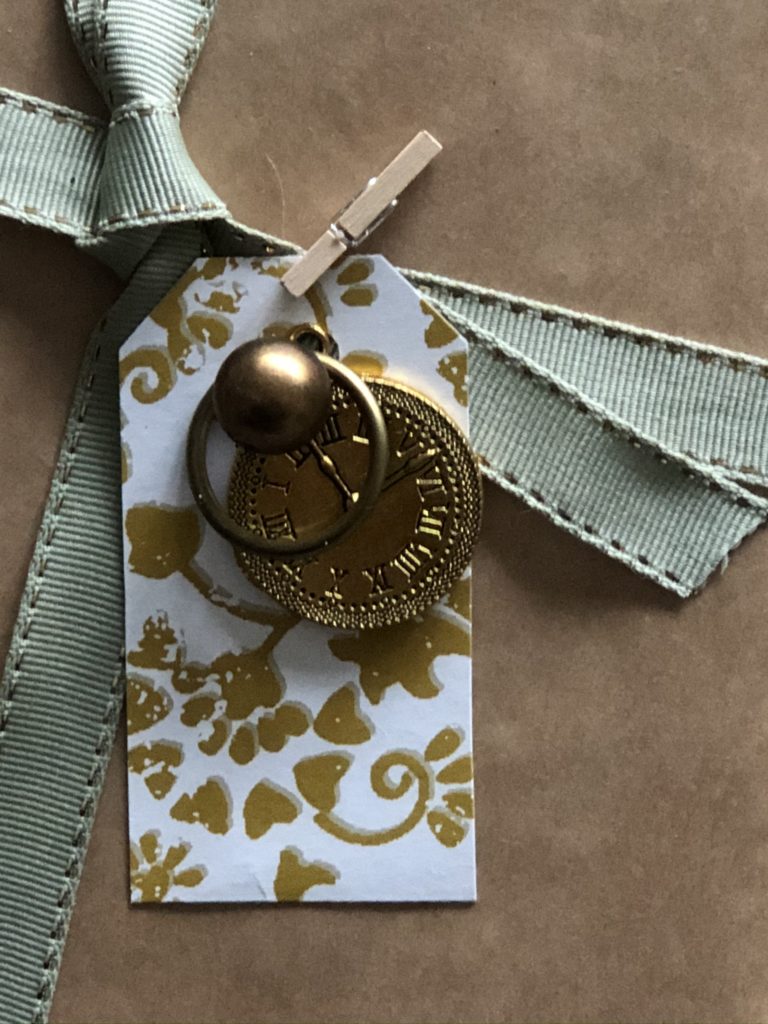 gold tag and gold embellishments on brown paper christmas wrapping