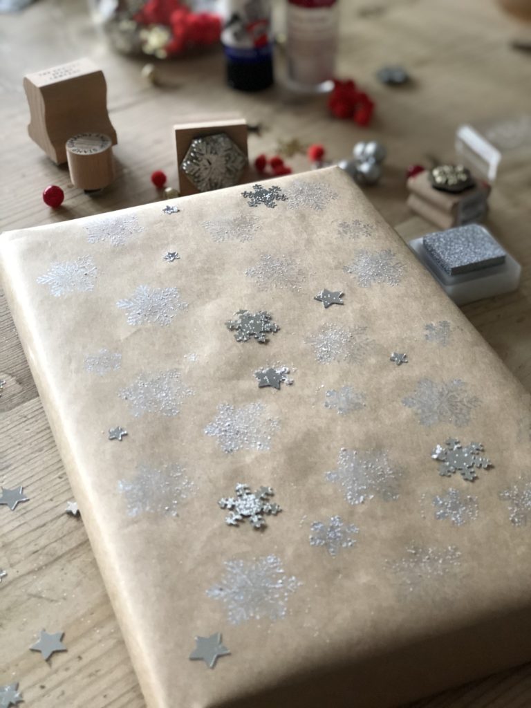 silver snowflake confetti on brown paper wrapping paper