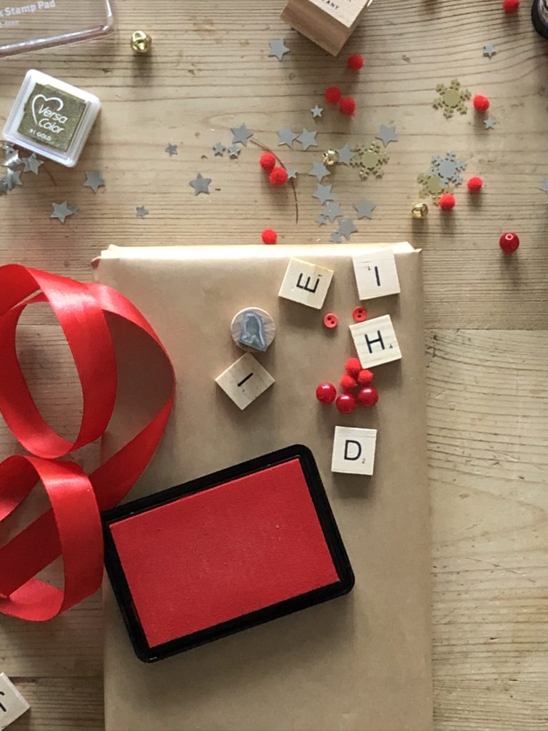 red ink pad, brown parcel and letter tiles