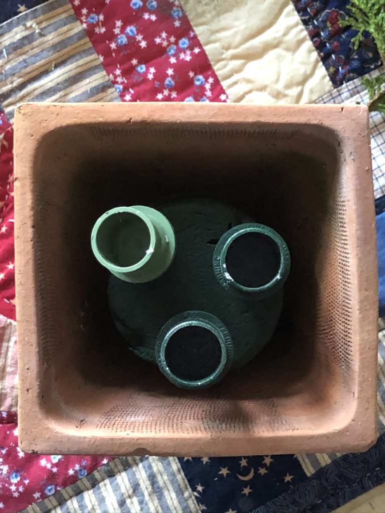 flat lay of candle holders in oasis in terracotta pot