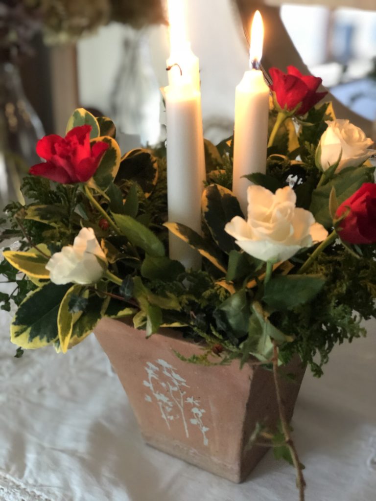 floral and candle display in terracotta pot