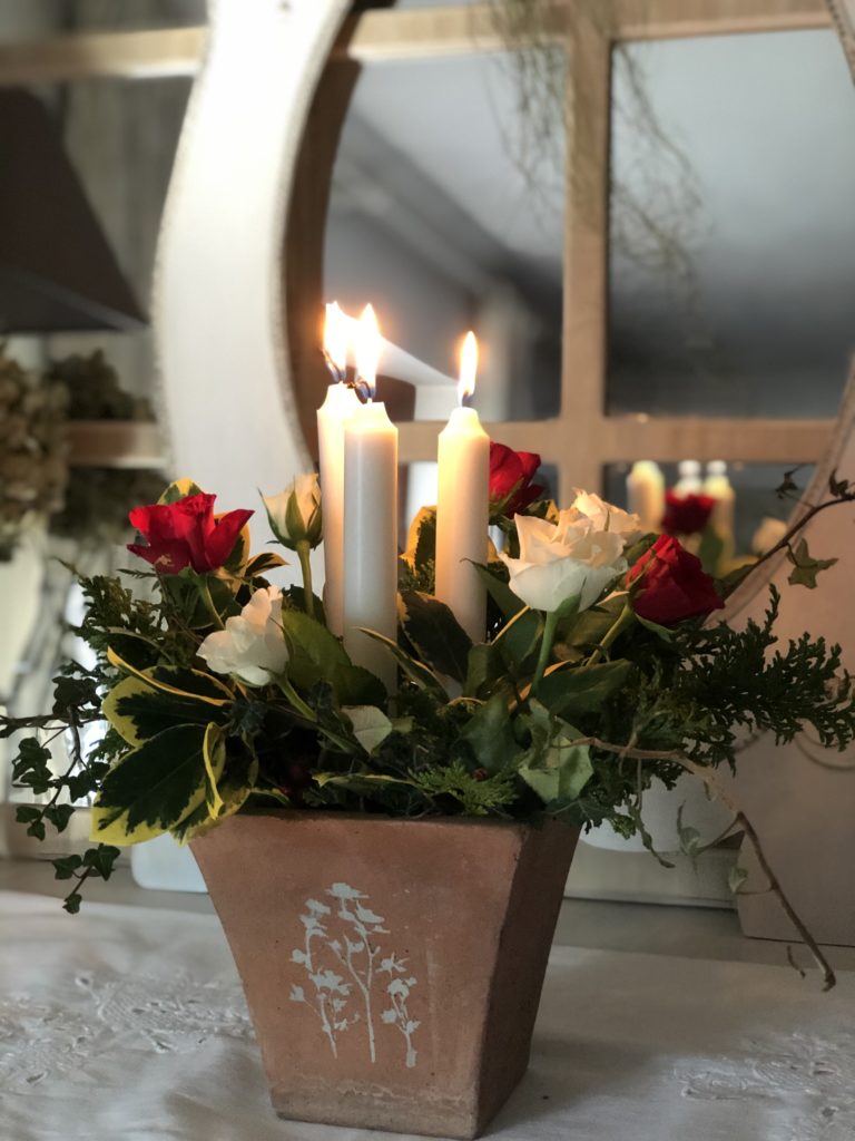 floral and candle display in terracotta pot