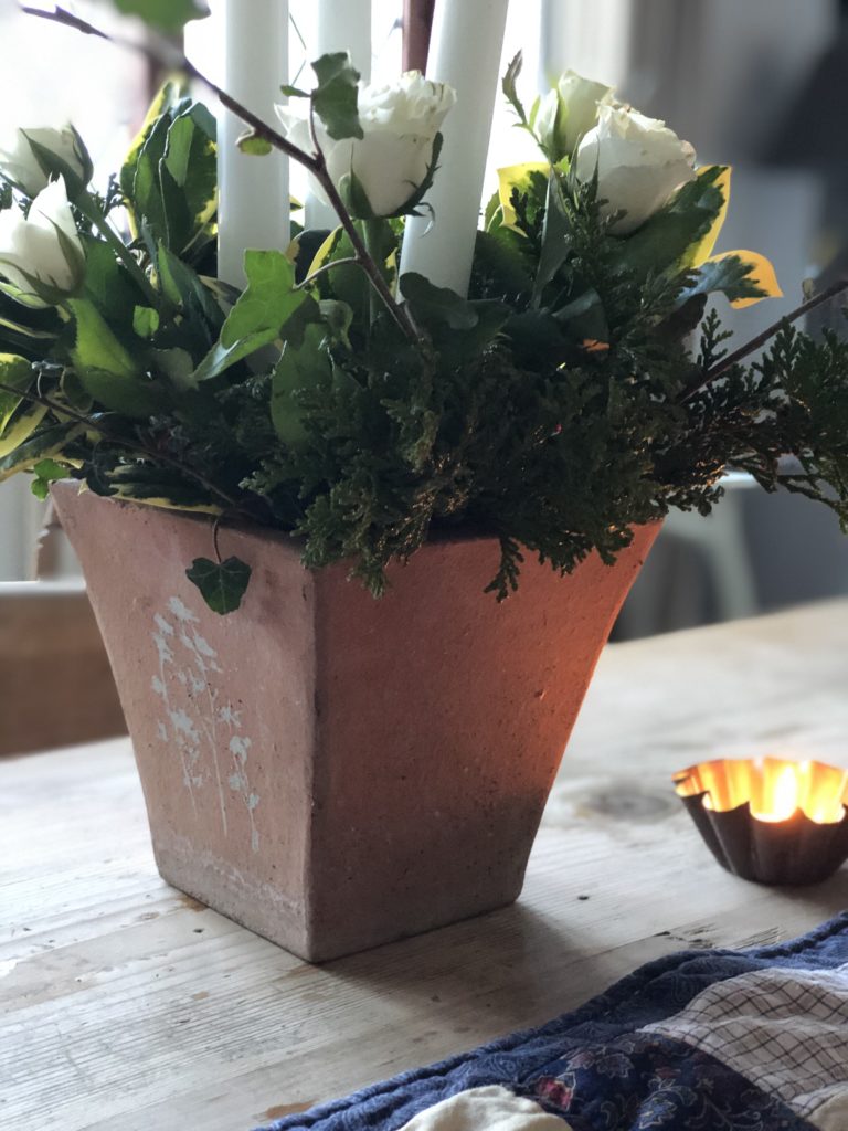 terracotta pot with foliage and candles