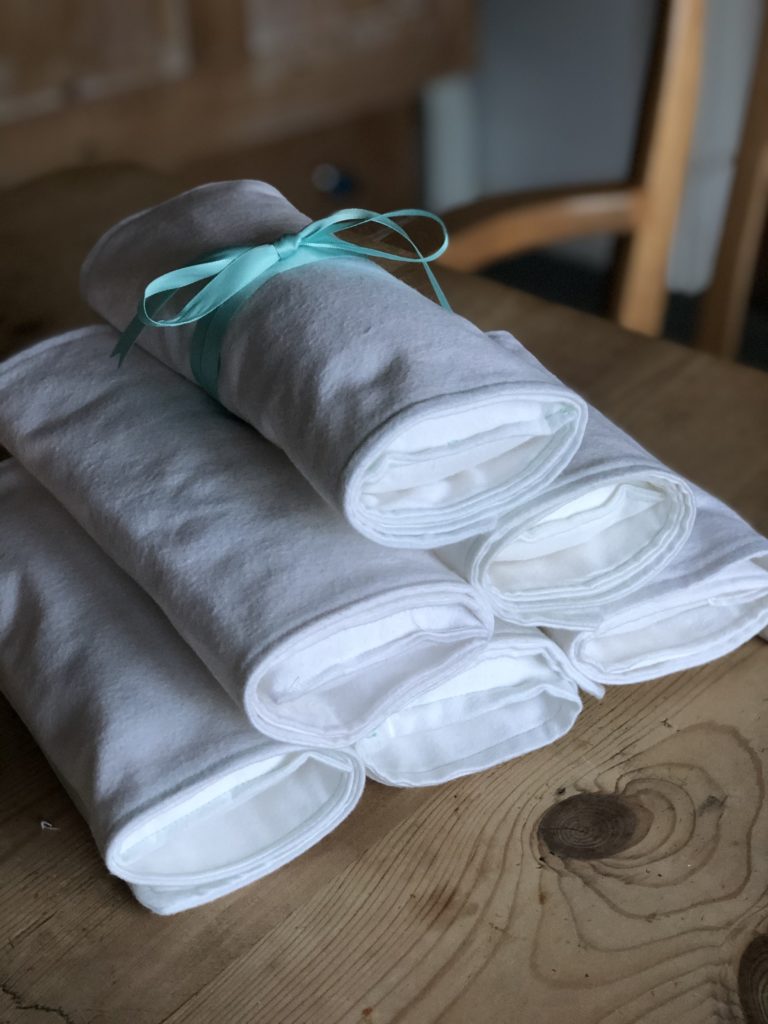 a stack of white bat wraps with green ribbon