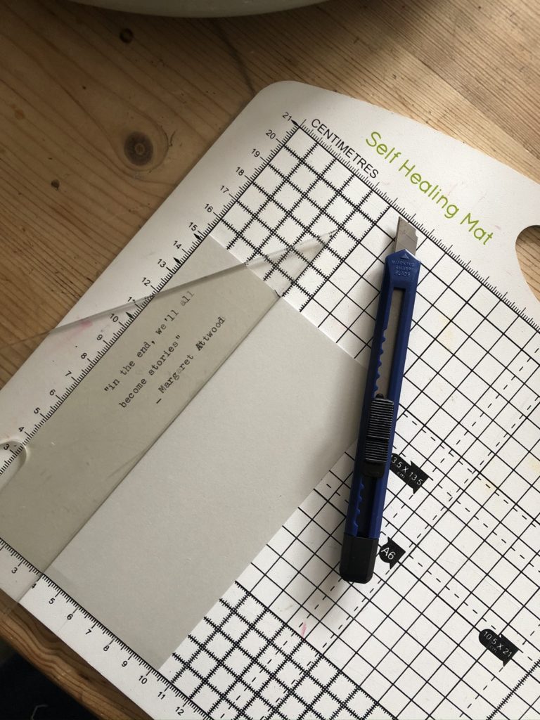 cutting a quote on card for a handmade bookmark