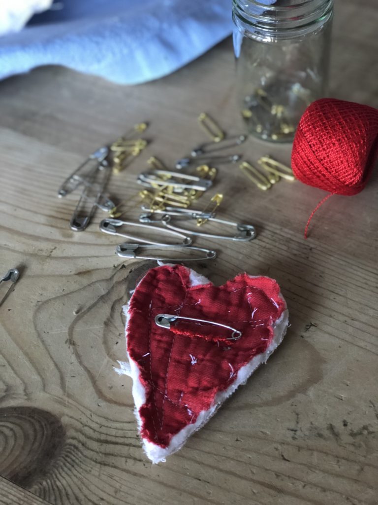 attaching safety pin on pink fabric brooch