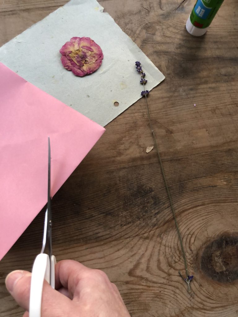 corner of pink envelope used to form a pocket on paper