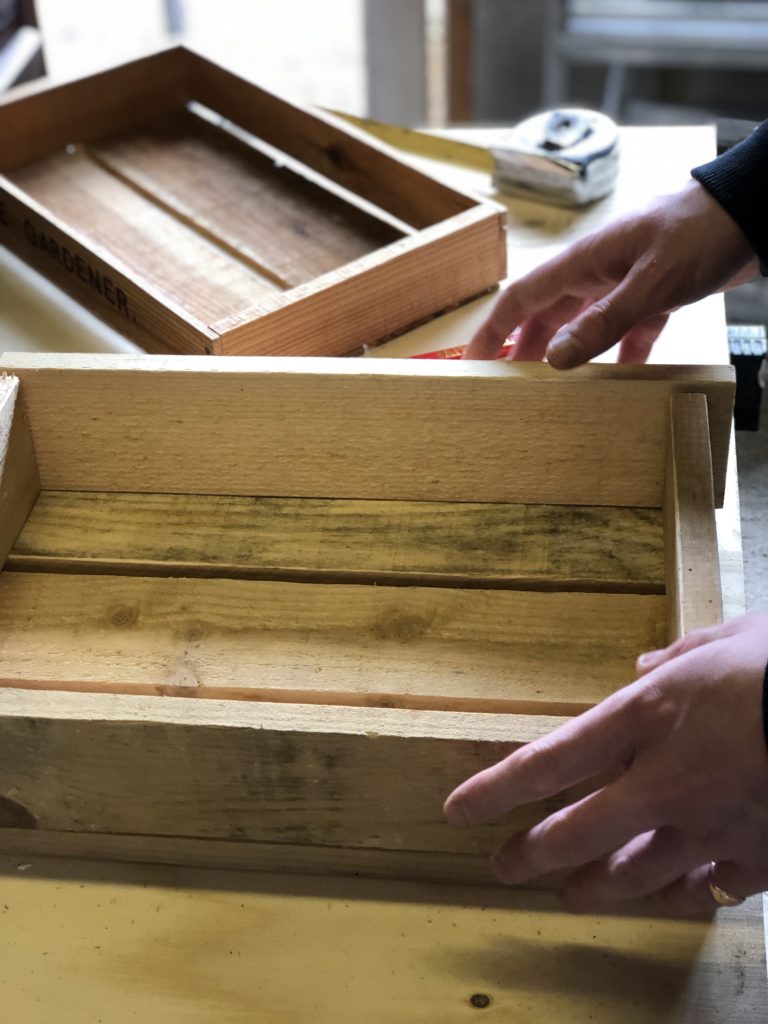 assembling wooden slats to make a little wooden storage crate