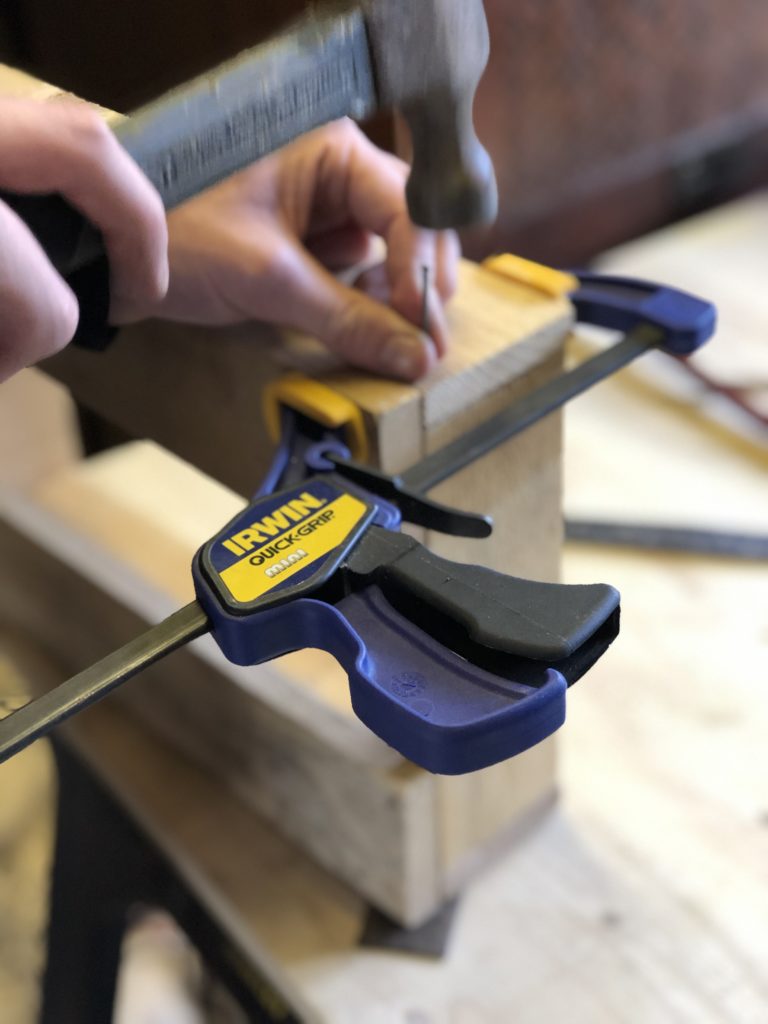 clamp holding wooden slats to make a small wooden crate