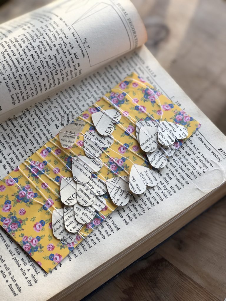 paper heart garland displayed on vintage book