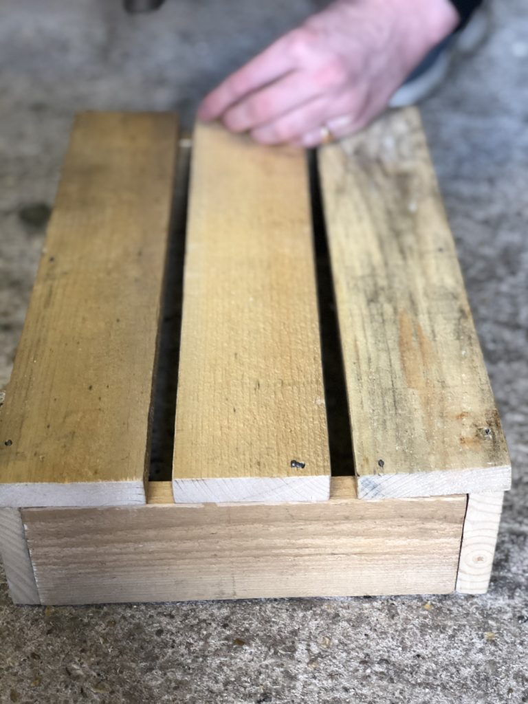 assembling wooden slats to make a little wooden storage crate