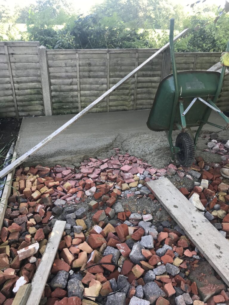 pouring concrete to create a small garden terrace